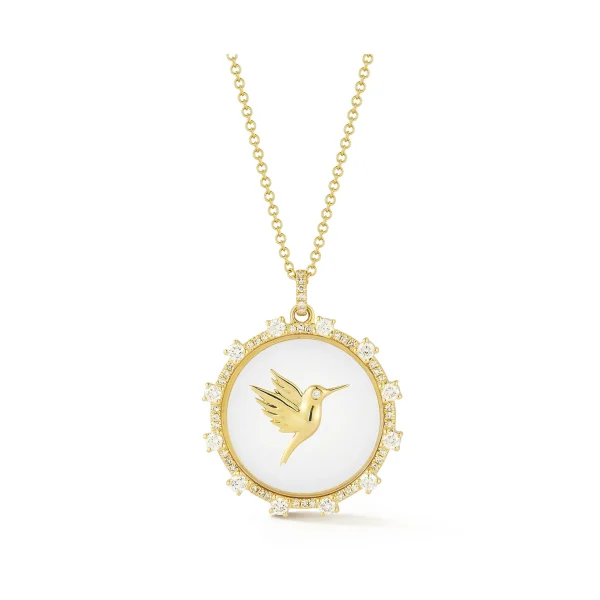 The Floating Hummingbird Necklace features a circular pendant with a raised gold hummingbird on a white background, bordered by sparkling stones.