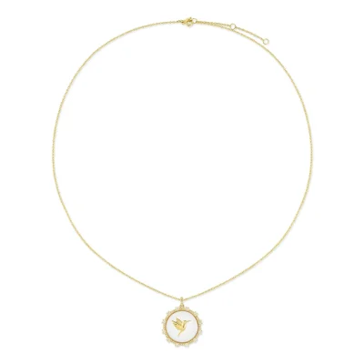 The Floating Hummingbird Necklace features a delicate gold chain and a round pendant with a gold hummingbird design on a white background, framed by an ornate gold border.