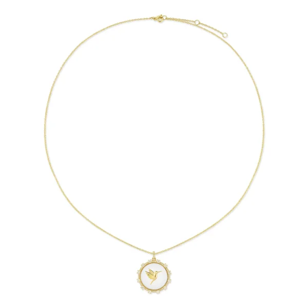 The Floating Hummingbird Necklace features a delicate gold chain and a round pendant with a gold hummingbird design on a white background, framed by an ornate gold border.